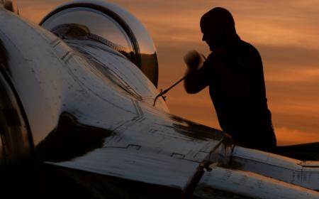 Aircraft being prepared against a sunset sky